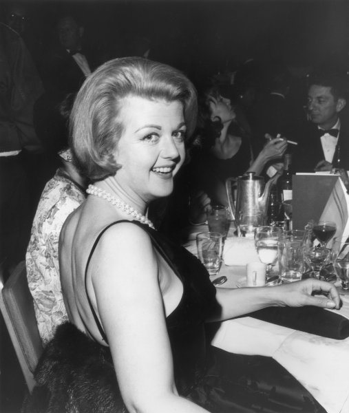 1955 - Abito nero scollatissimo con immancabile filo (doppio) di perle
