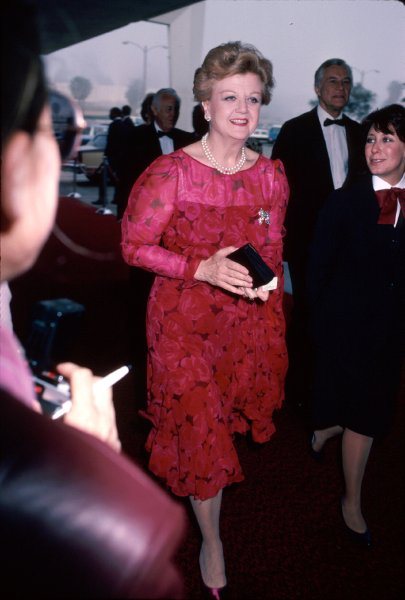 1986 - La Lansbury indossa un abito in crêpe con stampa floreale, sui toni del rosso. Perle: sempre presenti